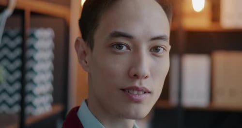 Closeup Slow Motion Portrait of Successful Young Businessman Looking at Camera Against Office