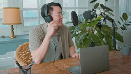 An asian man is using microphone podcasting