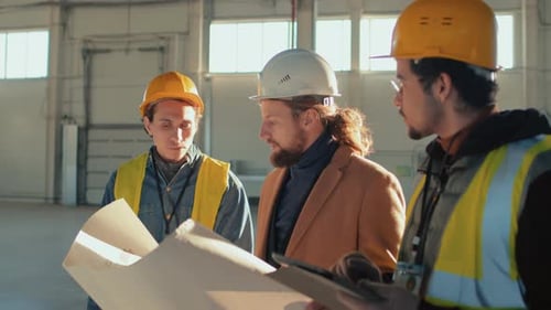 Homme d'affaires discutant du plan de construction avec des ouvriers du bâtiment