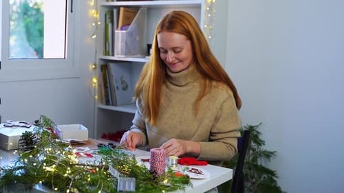 Young Red Haired Woman Create Christmas Toys Tree Decoration at Home or Woking Place Studio DIY