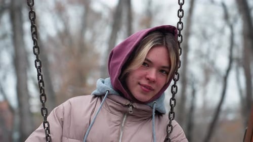 Young Lady Holding Swing Chain Resting Head in Winter Park