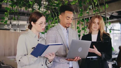 Team Collaborating on Laptop in Modern Office