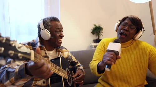 Senior Couple Singing and Playing Guitar at Home