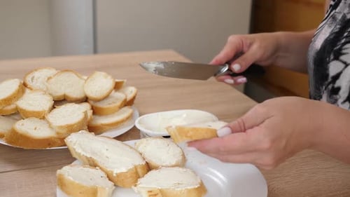 Woman Spreads Cream Cheese on Bread Slices