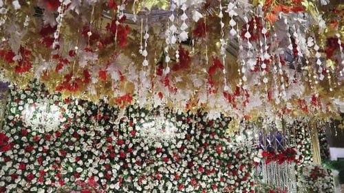 Die Bühne ist mit leuchtenden Blumen und einem eleganten weißen Kronleuchter geschmückt, der in einer Nahaufnahme aufgenommen wurde