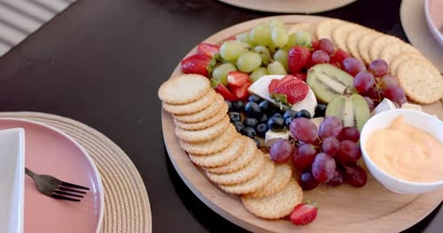 Assiette de service composée d'un assortiment de fruits, de fromages et de craquelins pour la cueillette