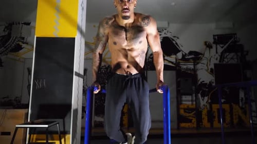 Muscular Afro American Sportsman Doing Push Ups on Parallel Bars at Modern Gym Strong African