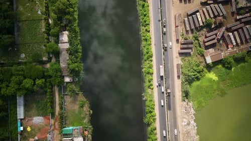 Vehicles are moving from a beautiful road in Dhaka city nearby a lake