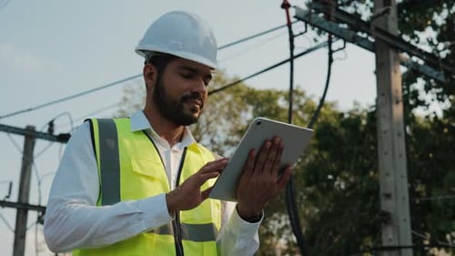 Engineer Using Tablet Near Power Lines