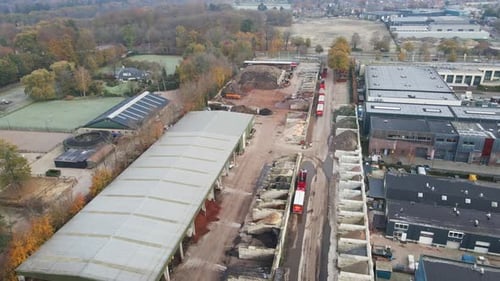 Flying over large quarry with piles of sand