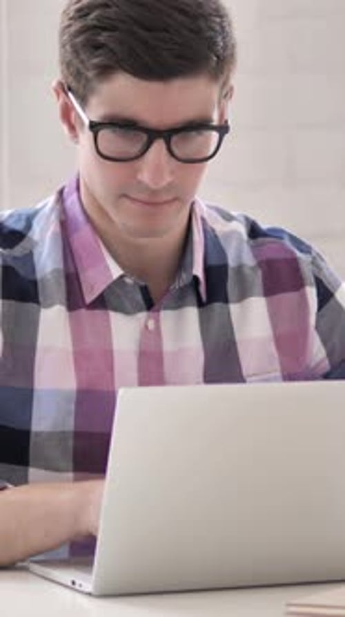Young Man Works at Laptop Inside Home