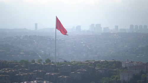 Wide Shot of Cityscape With Waving Red Flag