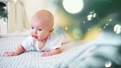 Adorable Infant Lying on Blanket near Christmas Lights