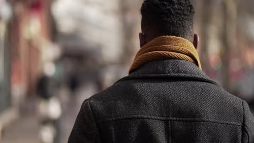 Back of black man walking outside in city