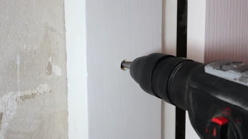 Power Drill Widens Hole in White Door Frame
