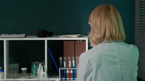 Female Scientist Holding Test Tube Examining Liquid
