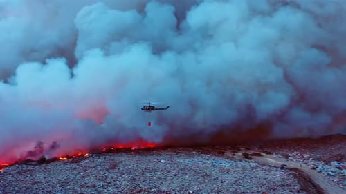 Vue aérienne d'une goutte d'eau d'hélicoptère sur des prairies en feu, des feux de forêt en Afrique, au milieu d'une épaisse
