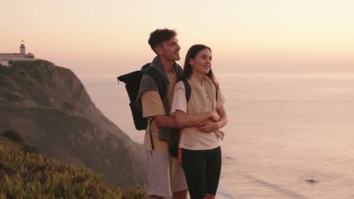 Travelers' Sunset Embrace on Cliff Edge
