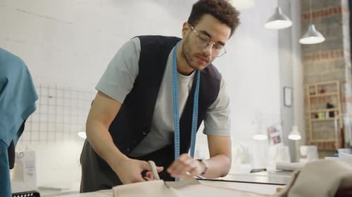 Tailor Cutting Fabric with Scissors in Dressmaking Workshop