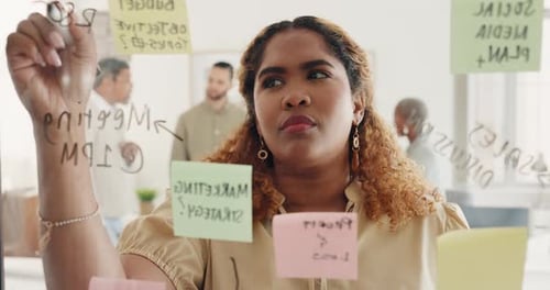 Woman Writing on Glass Board in Office