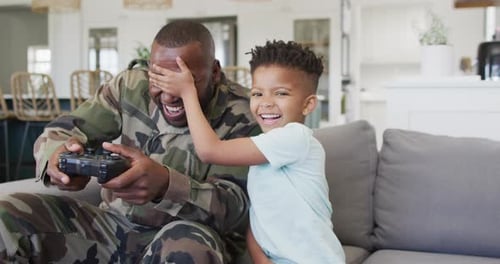 Father and Son Playing Together on Couch Indoors