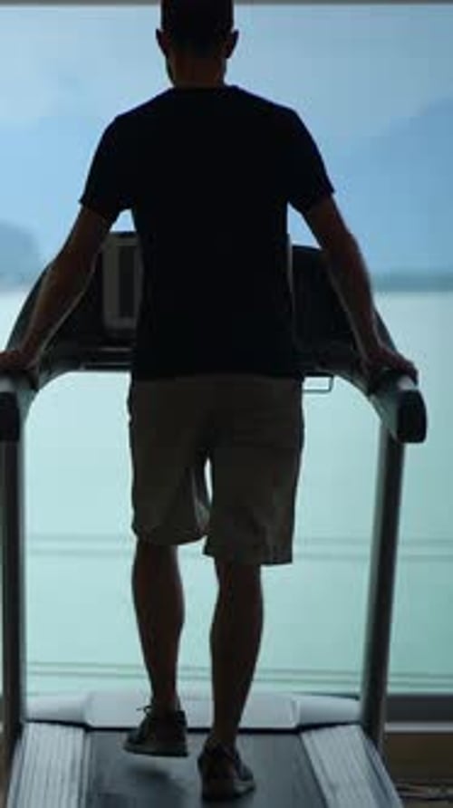 A Man Actively Engaging in Exercise on a Treadmill While Enjoying a Scenic View Around Him