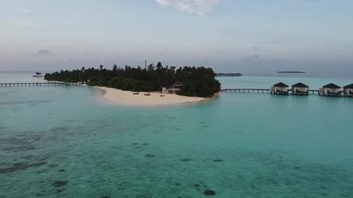 Aerial drone reveal shot of a small island in the Maldives at midday