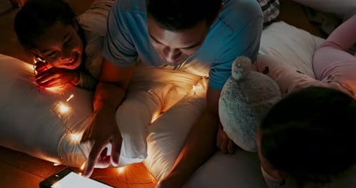 Father and Daughters Using Tablet at Bedtime