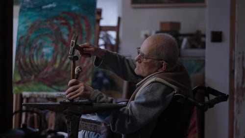 Senior Elderly Master Jeweler in Wheelchair Works in a Workshop