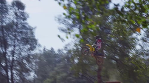 Man Riding Dirt Bike Jumps on Rural Track