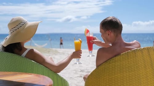Couple Chilling with Shakes on a Tropical Beach