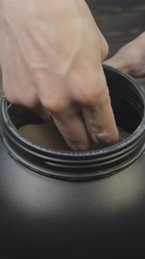 Vertical footage of a man taking mass gainer