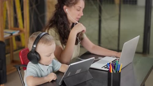Mother and Child Working on Devices at Table