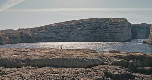 Aerial View of Brave Girl on Rock Face By Seaside with Powerful Waves