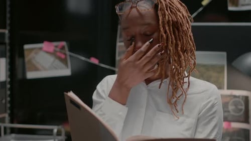 Determined Woman Reviews Case Files in Office