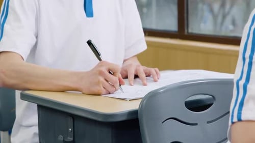 Enseignement académique, apprentissage et rédaction d'un examen, d'un test ou d'une évaluation par l'étudiant sur une table, à la main avec un stylo