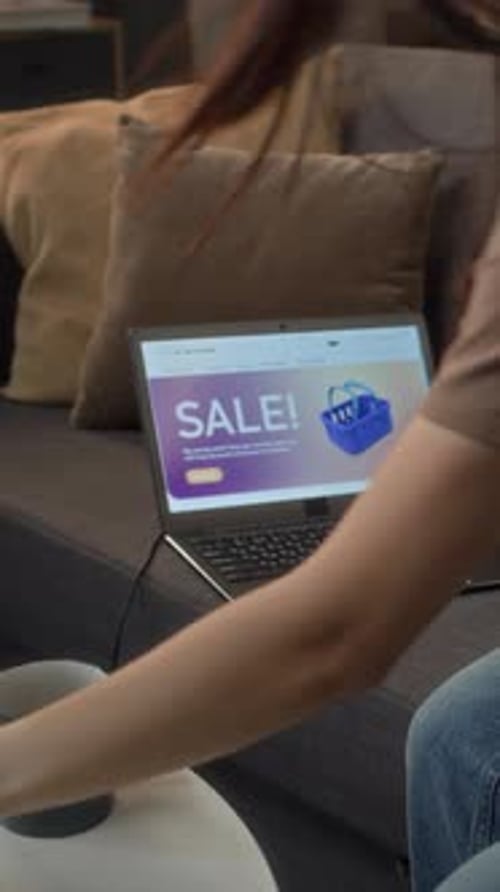 Woman shops online at home using laptop