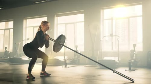 Profile Shot of Athletic Woman Performing Squats with Barbell Rod with One Ball