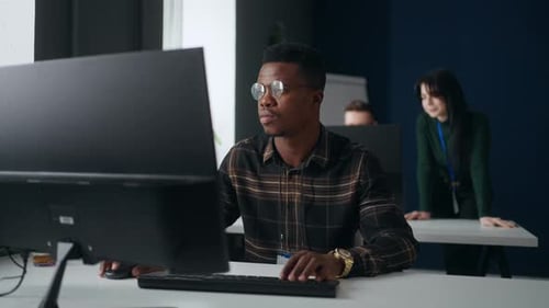 Büro der International Development Company Afrikanischer Mann, der mit einem Computerprogrammierer zusammenarbeitet