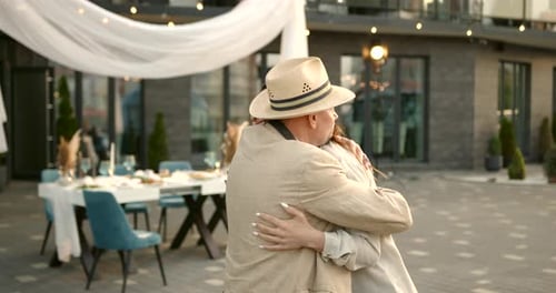 Charming Senior Man Hugging Young Woman Outdoors