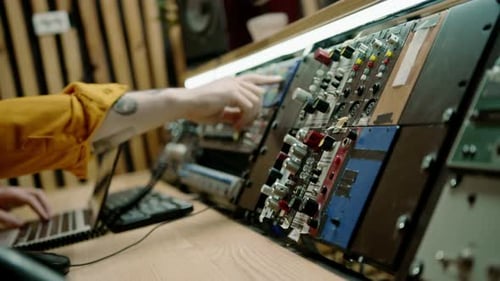 sound engineer works in music studio with monitors and equalizer mixing and mastering tracks