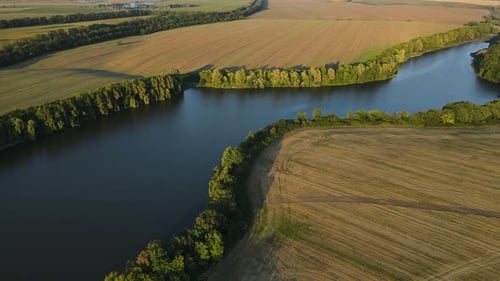 Aerial Panoramic View on the Wide River Among Agricultural Fields Drone Flies Up and Forward