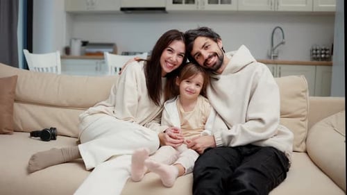Happy Family Poses on Couch in Bright Home