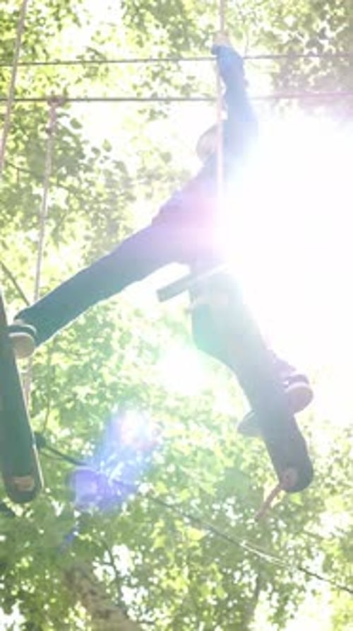 Child Enjoys Climbing on Outdoor Obstacle Course in Sunny Park