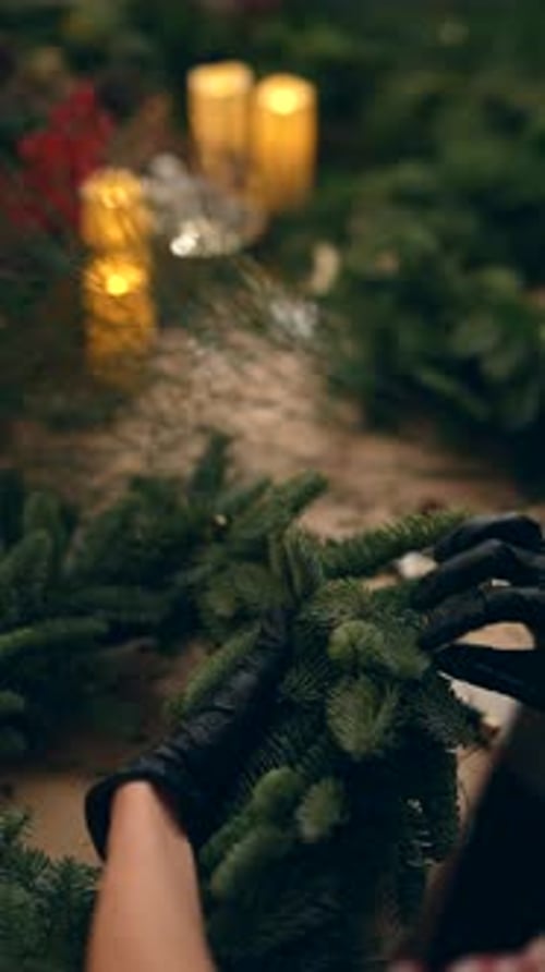 Woman Making Christmas Wreath with Pine Branches