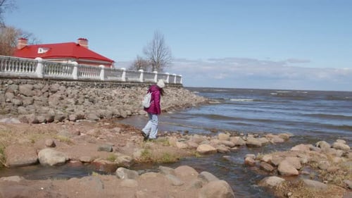 Woman Walking By Stream at Seaside Against Blue Sky