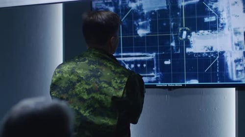 Military Personnel View Tracking Map in a Command Center
