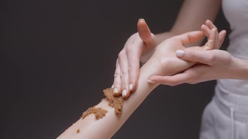 Woman Applies Exfoliating Scrub to Arm Close Up