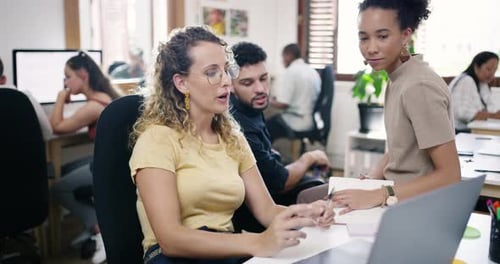 4k video footage of a group of young businesspeople using a laptop together in a modern office