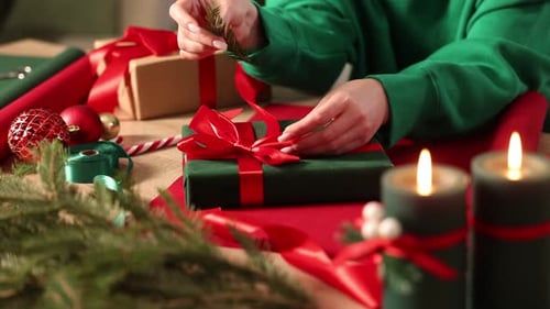 Woman Tying Bow on Christmas Gift at Home